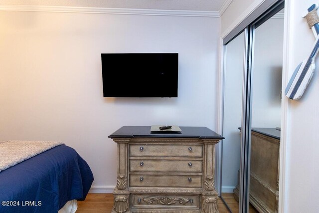 bedroom featuring ornamental molding and hardwood / wood-style floors