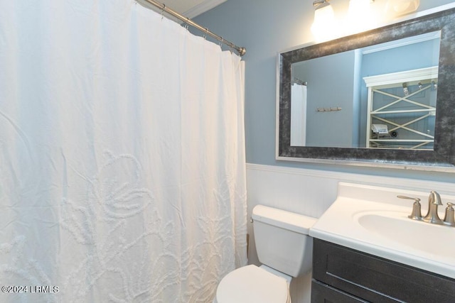 bathroom with ornamental molding, vanity, and toilet