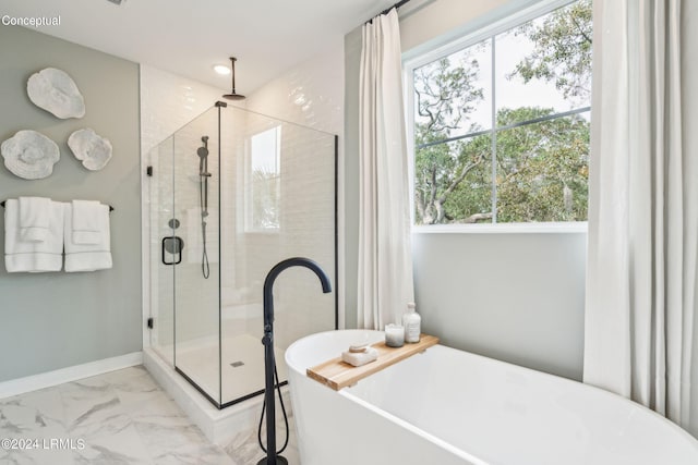 bathroom featuring a shower stall, marble finish floor, baseboards, and a freestanding tub
