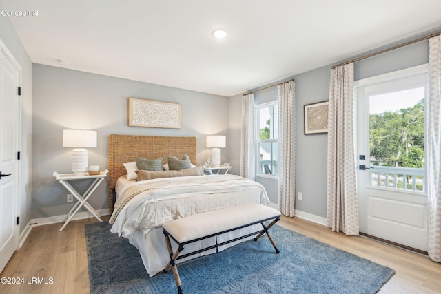 bedroom with light wood finished floors and baseboards