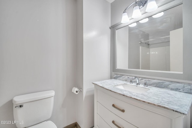 bathroom with a shower, vanity, and toilet