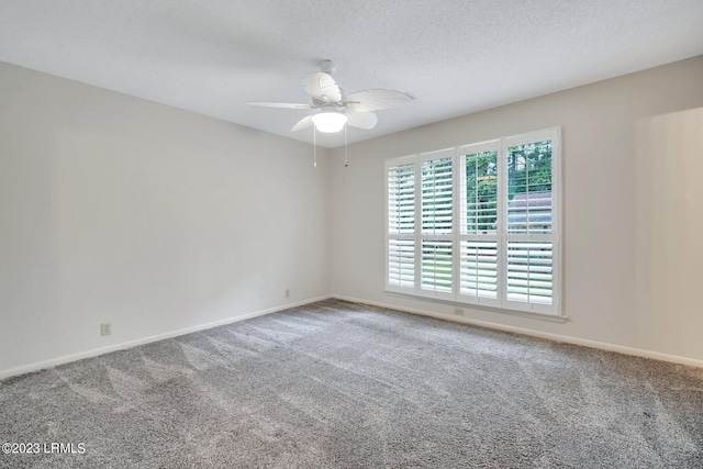 carpeted spare room featuring ceiling fan, a textured ceiling, and baseboards