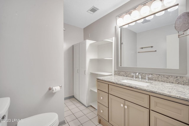 bathroom with visible vents, toilet, tile patterned flooring, a textured ceiling, and vanity