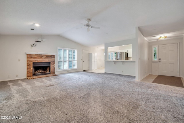 unfurnished living room with lofted ceiling, a fireplace, a ceiling fan, and light colored carpet