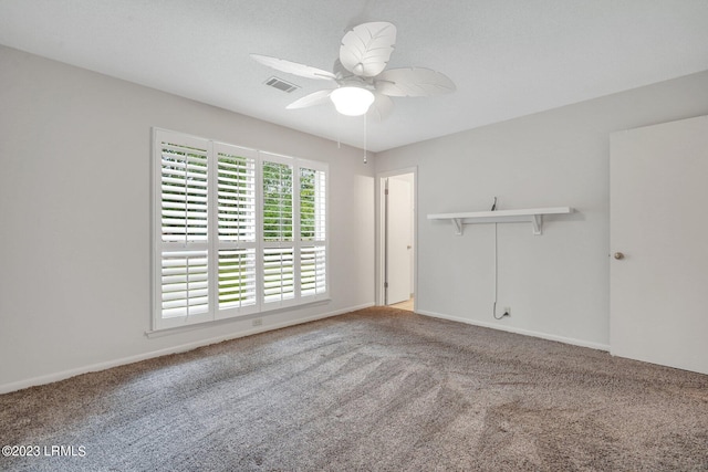 unfurnished room featuring baseboards, carpet flooring, visible vents, and a ceiling fan