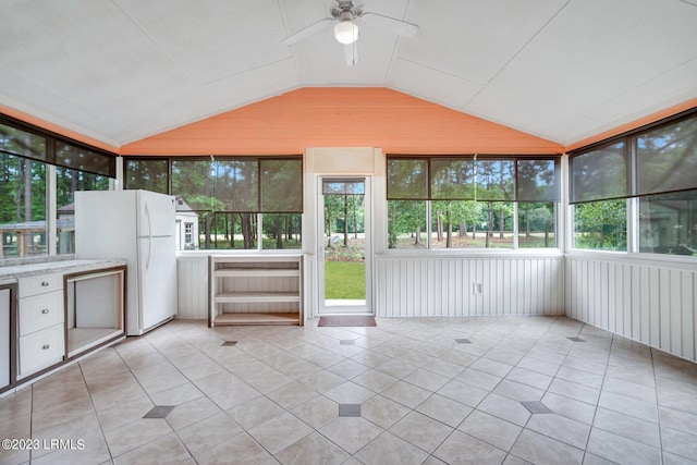 unfurnished sunroom with a ceiling fan and vaulted ceiling