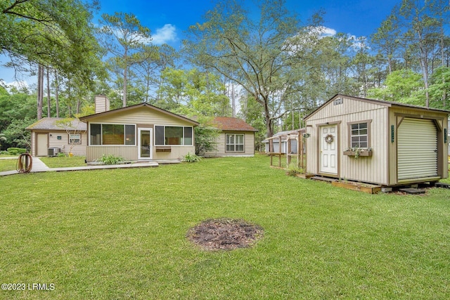 view of front of property with an outbuilding, central AC unit, a storage unit, a front lawn, and a chimney