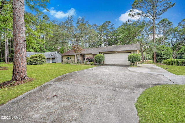 view of front of house featuring a garage, concrete driveway, and a front lawn