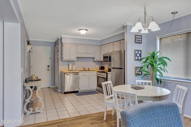 40 Folly Field Rd Unit G1, Hilton Head Island, SC 29928 - kitchen featuring appliances with stainless steel finishes, a chandelier, light countertops, ornamental molding, and decorative light fixtures