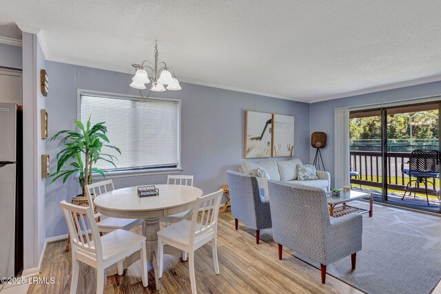 40 Folly Field Rd Unit G1, Hilton Head Island, SC 29928 - dining room featuring a chandelier, light wood-style flooring, crown molding, and a textured ceiling