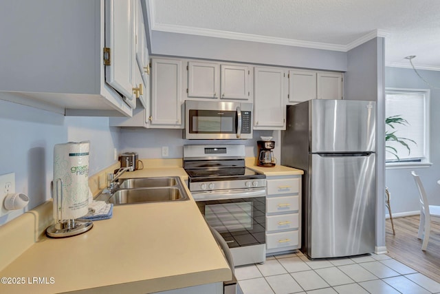 40 Folly Field Rd Unit G1, Hilton Head Island, SC 29928 - kitchen with appliances with stainless steel finishes, ornamental molding, light countertops, light tile patterned floors, and a textured ceiling