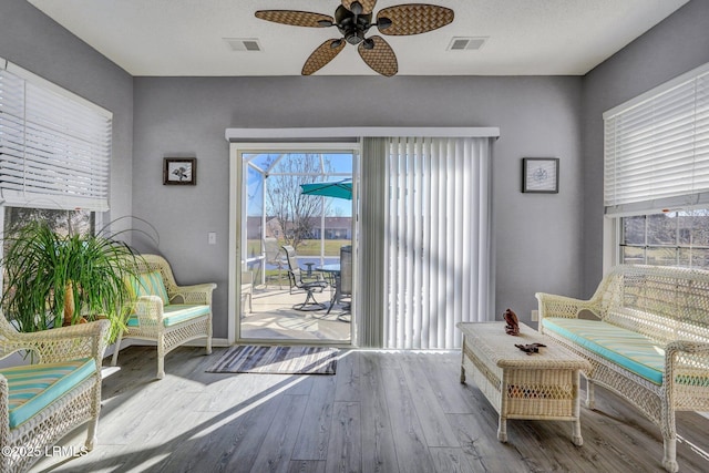 living area featuring visible vents, ceiling fan, light wood-style flooring, and baseboards