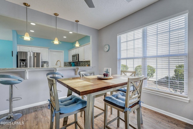 dining room with recessed lighting, ceiling fan, a textured ceiling, wood finished floors, and baseboards