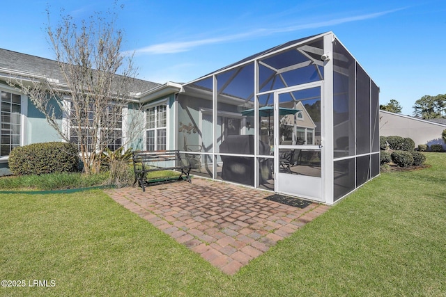 rear view of house featuring a lanai, a patio area, stucco siding, and a yard