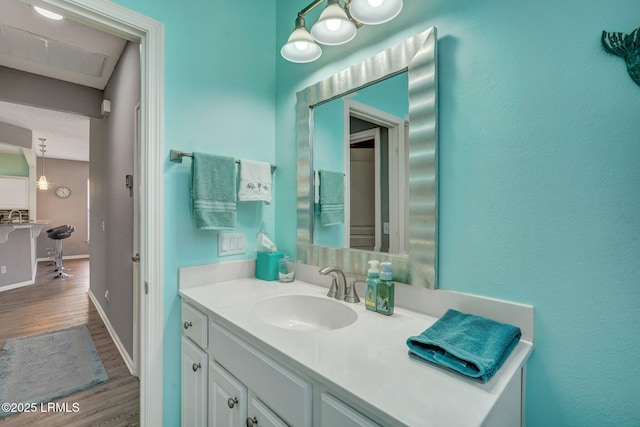 bathroom with vanity, baseboards, and wood finished floors