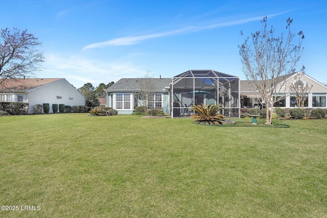 rear view of house featuring a lawn and a lanai