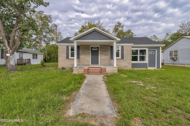 bungalow-style home with covered porch and a front yard