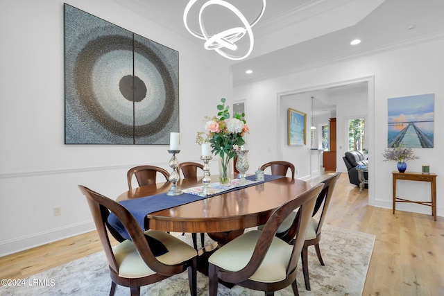 dining area featuring ornamental molding, an inviting chandelier, and light hardwood / wood-style flooring