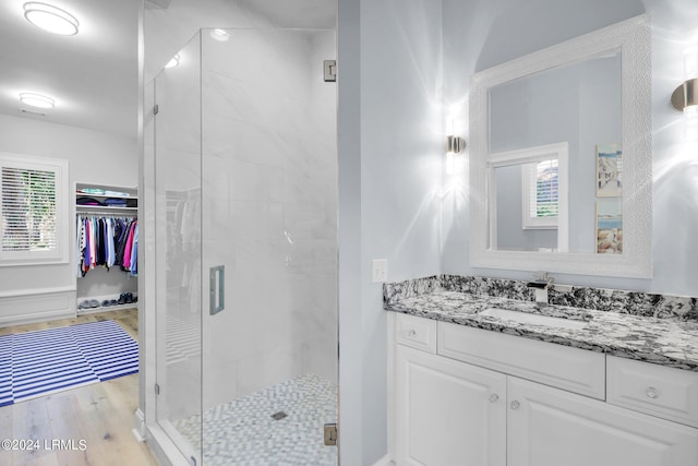 bathroom featuring an enclosed shower, vanity, and hardwood / wood-style floors