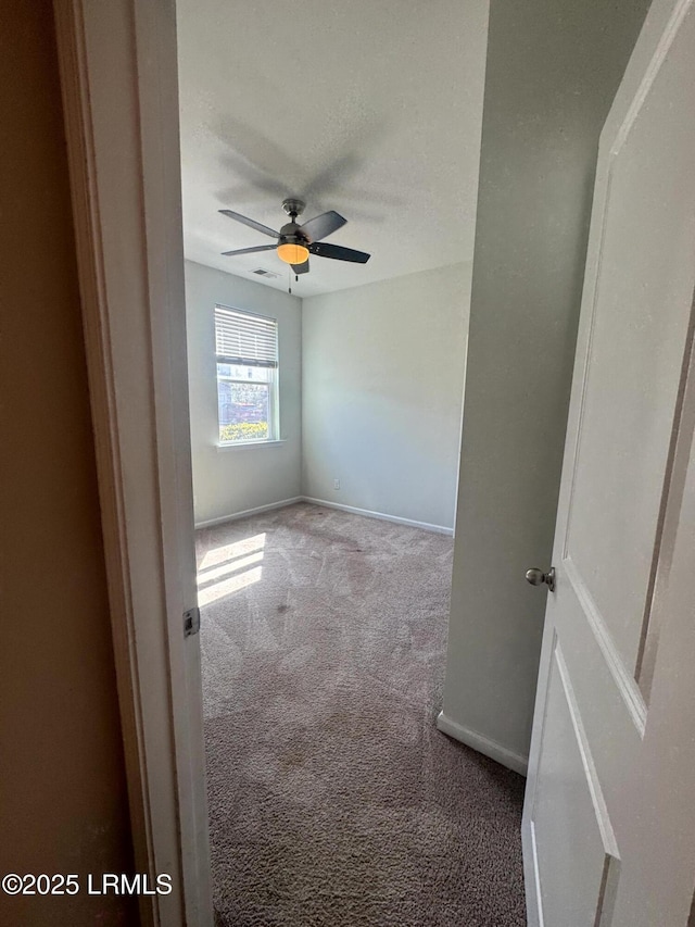 unfurnished room with visible vents, baseboards, ceiling fan, carpet floors, and a textured ceiling