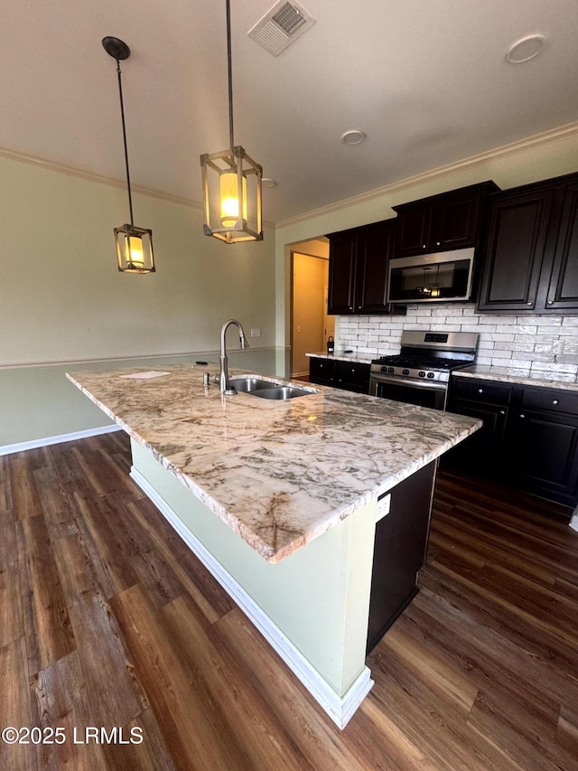 kitchen featuring dark wood-style floors, visible vents, a sink, appliances with stainless steel finishes, and tasteful backsplash