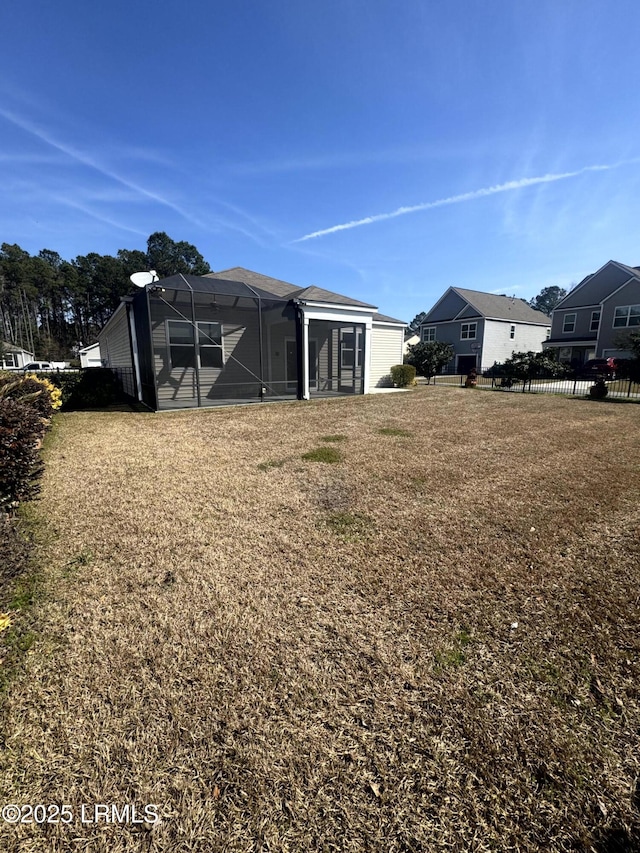 view of yard with a lanai and fence