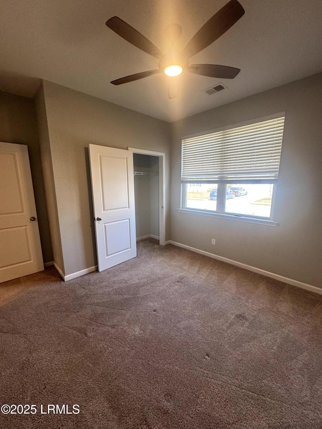 unfurnished bedroom featuring visible vents, a ceiling fan, a closet, carpet, and baseboards