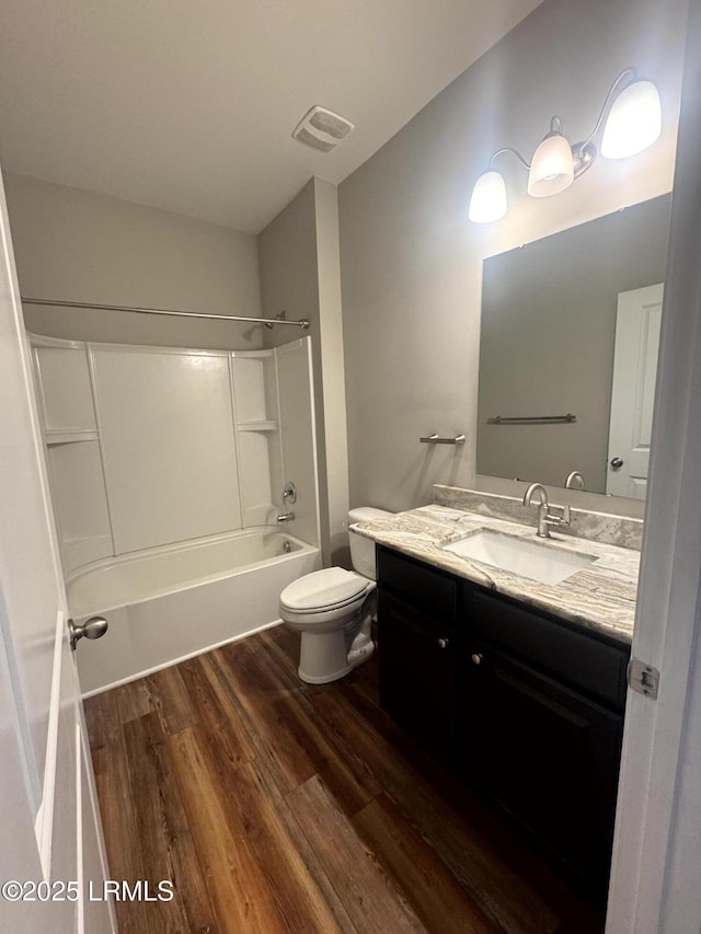 bathroom with visible vents, toilet, wood finished floors, tub / shower combination, and vanity