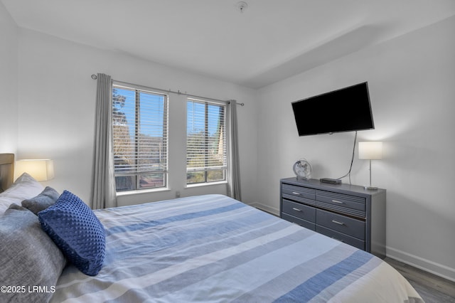 bedroom with dark wood-style flooring and baseboards