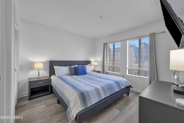 bedroom with light wood-type flooring and baseboards