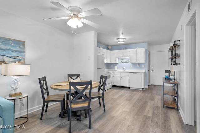 dining area featuring light wood-style floors, visible vents, baseboards, and a ceiling fan