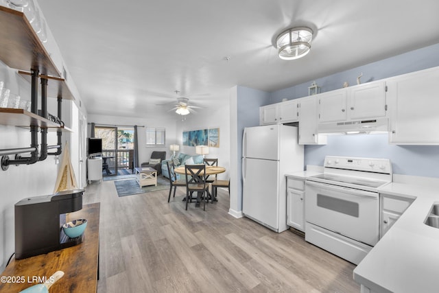 kitchen featuring white appliances, under cabinet range hood, white cabinets, and light countertops