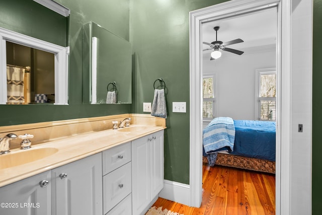 ensuite bathroom with wood finished floors, a sink, ensuite bath, and double vanity