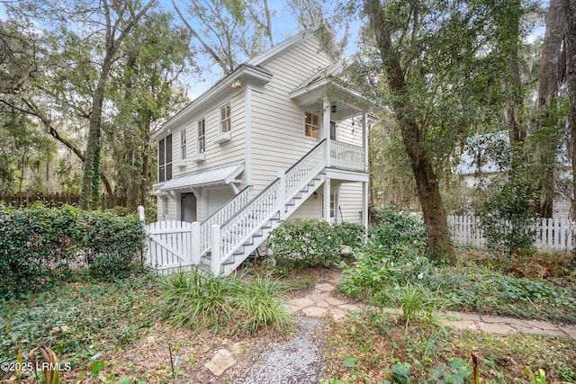 view of front of property with stairway and fence