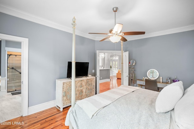 bedroom featuring baseboards, a ceiling fan, wood finished floors, ensuite bathroom, and crown molding