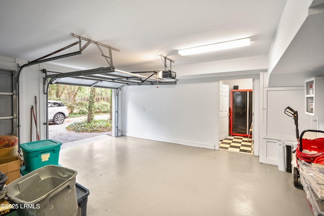 garage with baseboards and a garage door opener