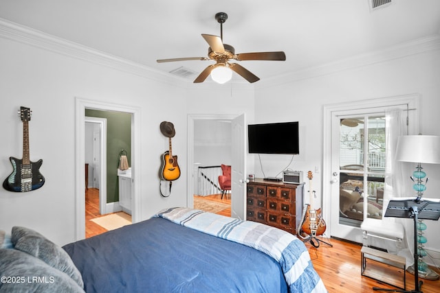 bedroom with ornamental molding, light wood-style floors, visible vents, and access to exterior