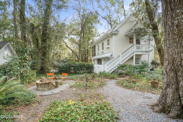 view of property exterior with stairway and a fire pit