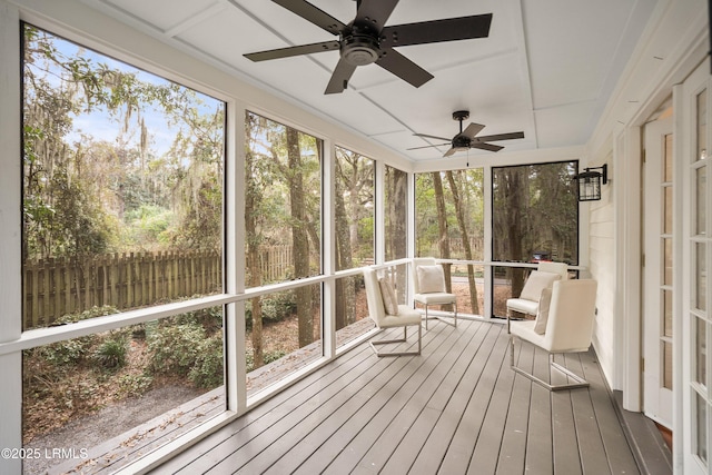 unfurnished sunroom with plenty of natural light and a ceiling fan