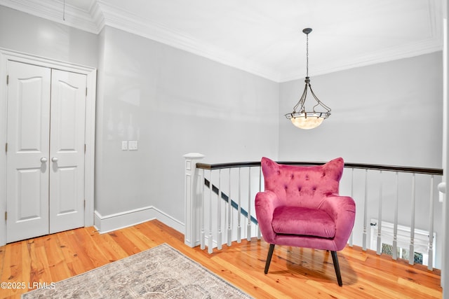 living area featuring ornamental molding, wood finished floors, an upstairs landing, and baseboards