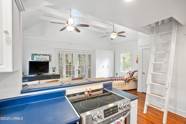 kitchen with french doors, dark wood-style flooring, stainless steel electric range oven, a ceiling fan, and vaulted ceiling