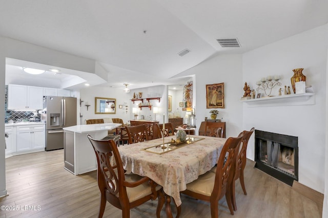 380 Marshland Rd Unit H34, Hilton Head Island, SC 29926 - dining room with a fireplace, lofted ceiling, visible vents, and light wood-type flooring