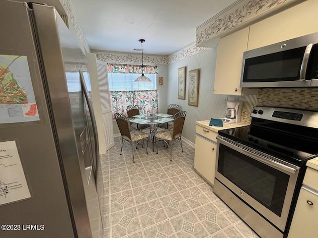 kitchen with pendant lighting, white cabinetry, ornamental molding, and stainless steel appliances