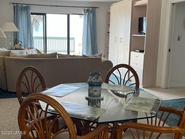 dining space featuring a water view and carpet floors