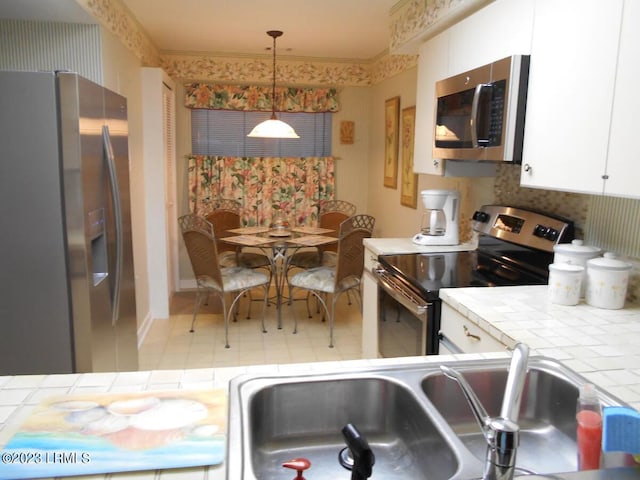 kitchen with stainless steel appliances, sink, and white cabinets