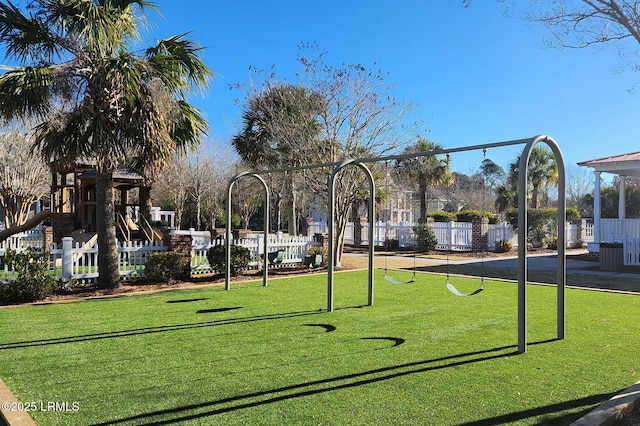 view of community with playground community, a yard, and fence