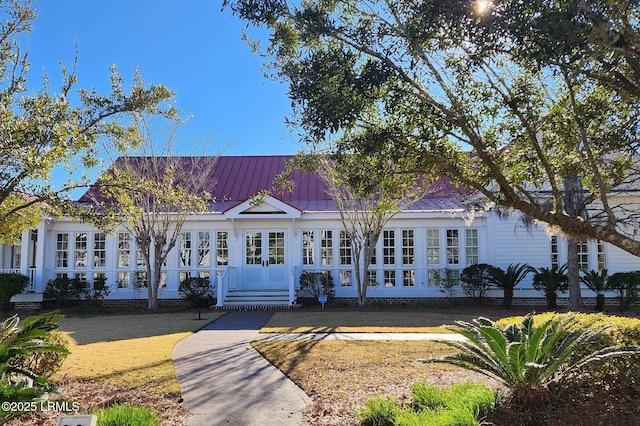 view of front of home with a standing seam roof, metal roof, and french doors