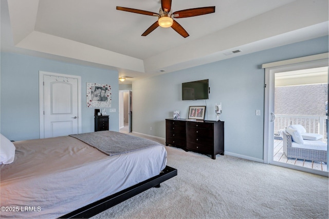 carpeted bedroom featuring baseboards, visible vents, a ceiling fan, access to exterior, and a tray ceiling