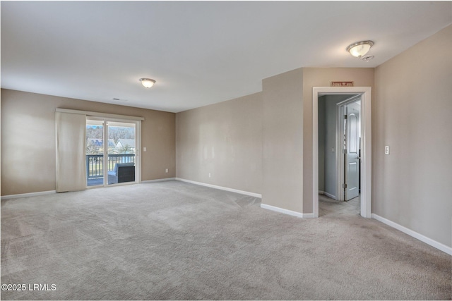 carpeted spare room featuring baseboards