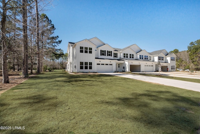 modern farmhouse featuring a front lawn, a garage, board and batten siding, and driveway